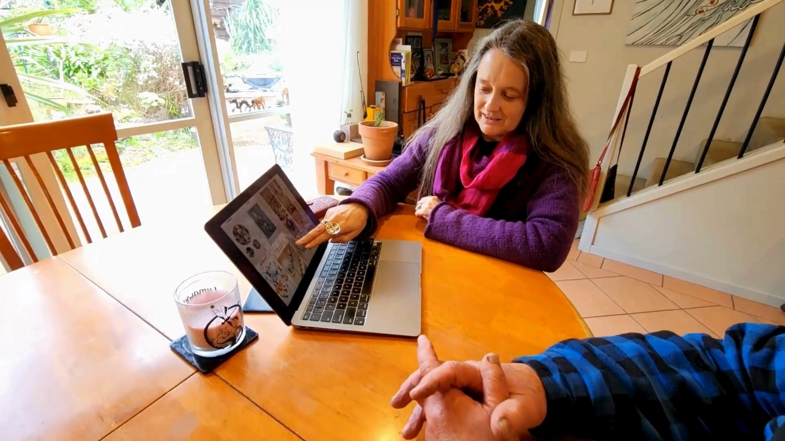 Cinnamon presenting a digital portfolio of local Surfcoast art to a client, offering personalized recommendations and insights.