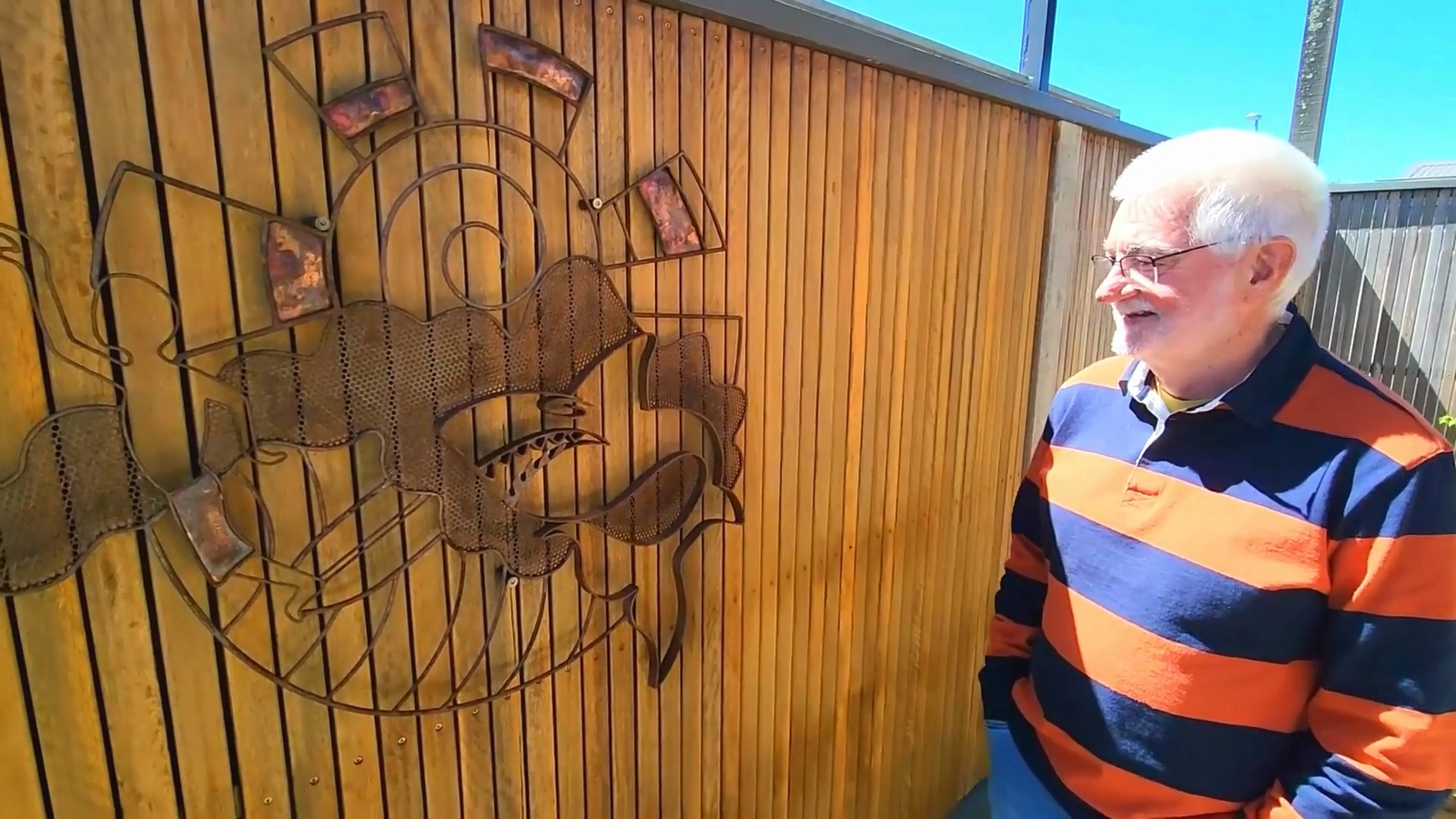 Geoff holding a custom art piece commemorating the Torquay Pointers, guided by Cinnamon’s expertise as a Surfcoast art advisor.