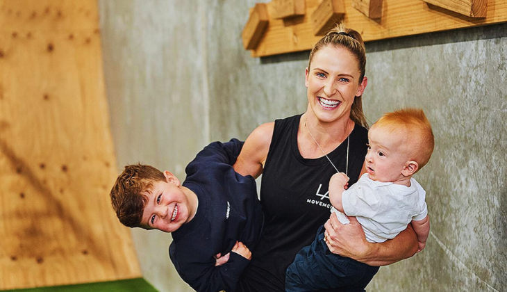 Larn, owner of LA Movement and mum of two, holding her kids inside the gym in Torquay.