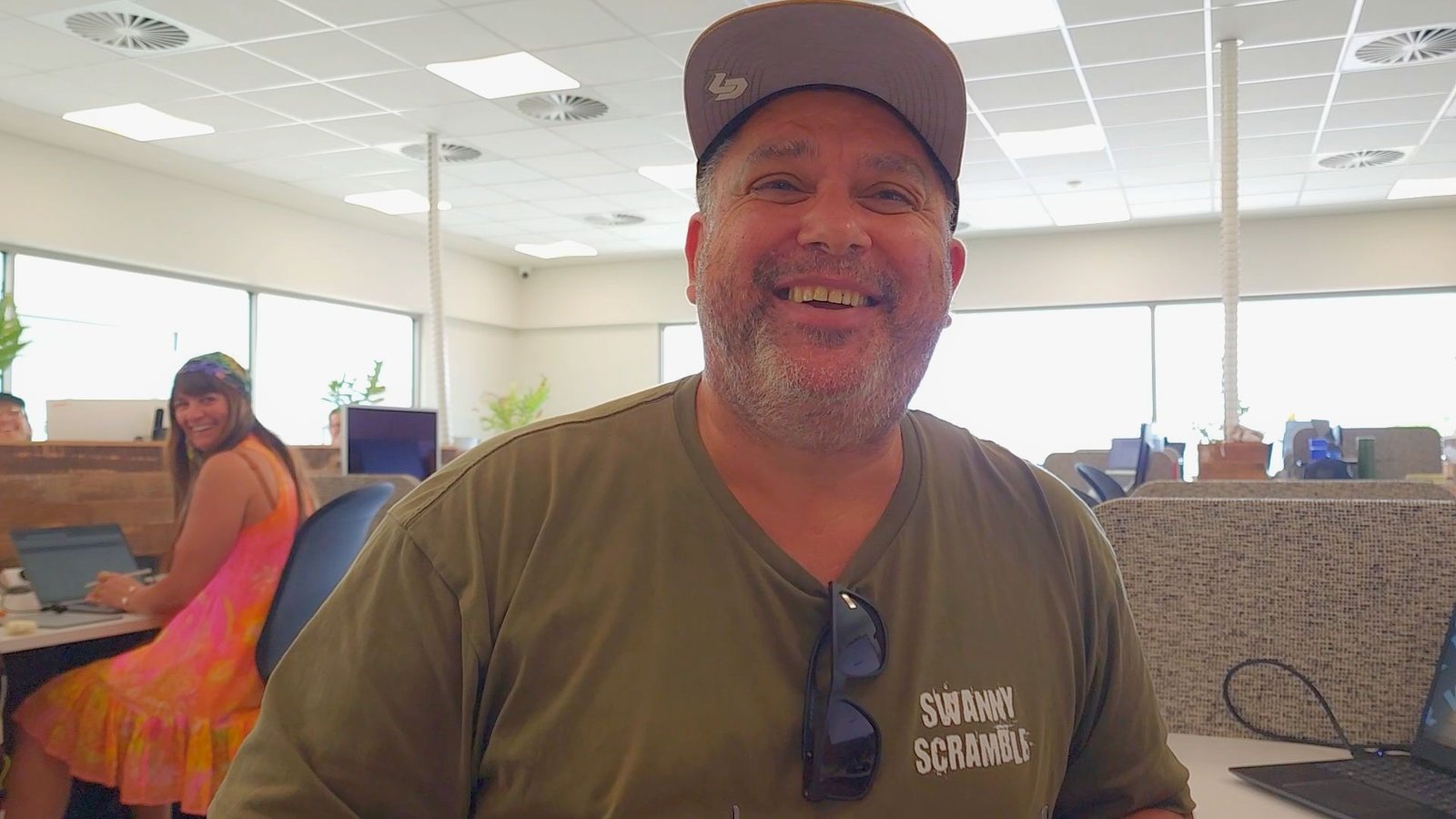 Matt from Wild Boar Bike Racks smiling at his desk at Happy Spaces, illustrating his story about finding connection and overcoming isolation.