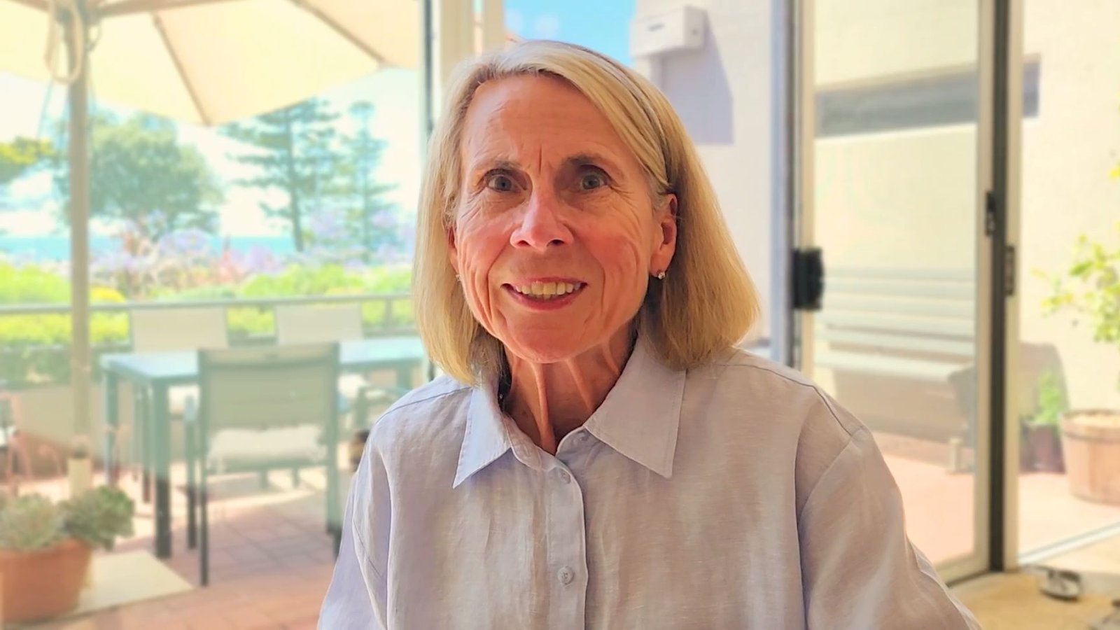 Portrait of Jan smiling warmly, looking happy and settled after her customer success story experience with SingLisa Music and Healing Sounds in Torquay.